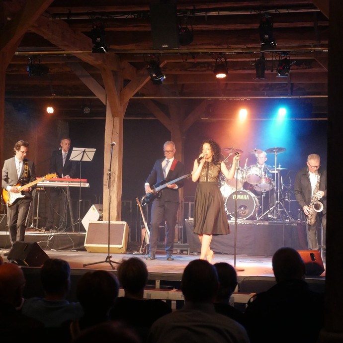 Dr. Schlager und die Marilyn Boadu Band spielen ein Lied auf der Bühne beim Dalheimer Sommer. (vergrößerte Bildansicht wird geöffnet)
