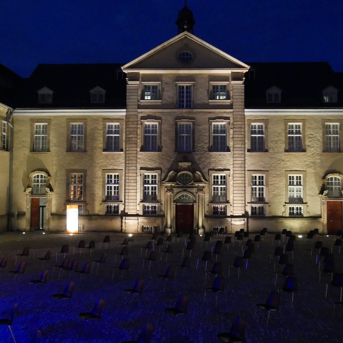 Das Foto zeigt den Blick auf die gestellten Stühle im Ehrenhof vor der barocken Klosterfassade. (öffnet vergrößerte Bildansicht)